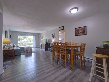 A dining room with a wooden table and chairs.